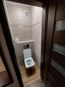 a small bathroom with a toilet in a stall at Studio 61 Apartment in Ełk