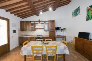 cocina y comedor con mesa y sillas en Il Pino - appartamento Alloro, en Cecina