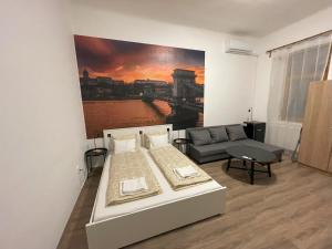 ein Schlafzimmer mit einem Bett und einem Sofa und einem Gemälde in der Unterkunft MaNo Guesthouse Budapest in Budapest
