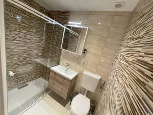 a bathroom with a toilet and a sink and a shower at MaNo Guesthouse Budapest in Budapest