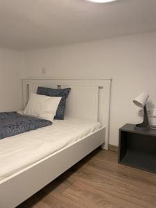 a bedroom with a bed with a lamp on a table at MaNo Guesthouse Budapest in Budapest