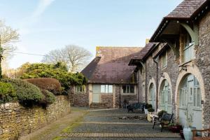 een oud stenen gebouw met een geplaveide straat bij No 9 Rowden in Noss Mayo
