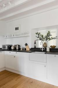 een keuken met witte kasten en een aanrechtblad bij No 9 Rowden in Noss Mayo