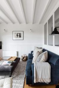 een woonkamer met een blauwe bank en een kleed bij No 9 Rowden in Noss Mayo