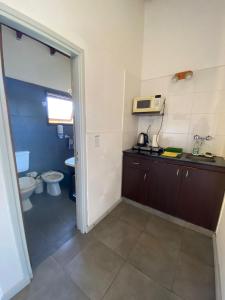 a small bathroom with a toilet and a sink and a counter at Complejo San Cristobal in Santa Clara del Mar