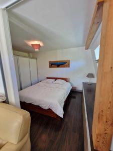 1 dormitorio pequeño con 1 cama y 1 silla en Hameau de la Brelaudière, en Jullouville-les-Pins