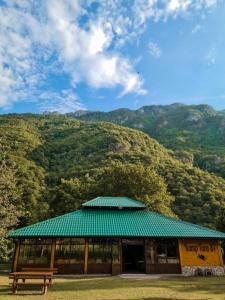 a building with a bench in front of a mountain at Rafting Camp Tara 87 in Hum