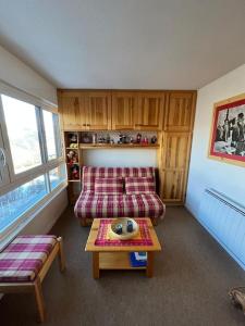 a living room with a couch and a table at Studio cosy à vue Panoramique in Puy-Saint-Vincent