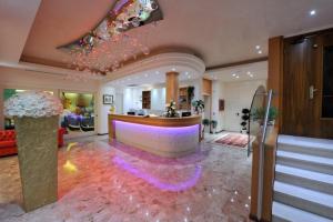 a lobby with a bar with a pink carpet at Hotel Ca' D'Oro in Bibione