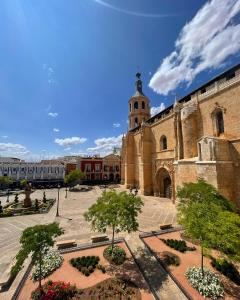a courtyard of a building with a clock tower at Blanco y Añil Plaza in Valdepeñas
