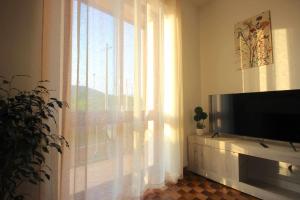 a living room with a television and a window at Case VR Holiday Appartamenti Bellavista in San Mauro di Saline