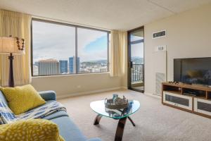 a living room with a couch and a tv at Honolulu Condo Stay with Balcony Walk to Beaches! in Honolulu