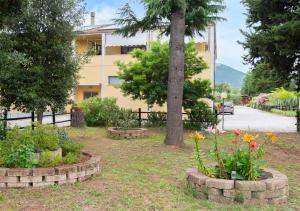 park z kwiatami, drzewem i budynkiem w obiekcie Art Beds & Garden 9 beds between the sea, thermal baths, and the Tuscan countryside w mieście Suvereto
