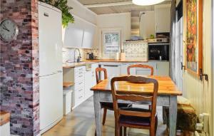 una cucina con tavolo e sedie in legno di The Woodpecker Cottage Tree a Salterød