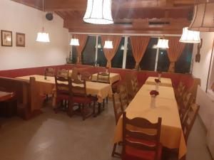 a dining room with tables and chairs and windows at Kupreski san1 in Kupres