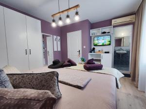 two beds in a room with purple walls at AMORE Obzor in Obzor