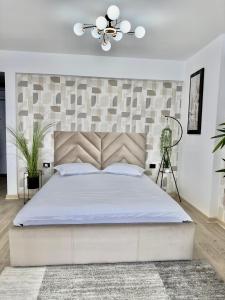 a bedroom with a large bed with a large headboard at Aqua Vista Infinity Spa & Pool Studio Lux in Mamaia Sat/Năvodari