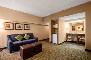 a living room with a blue couch and a table at Comfort Suites at Woodbridge in Avenel