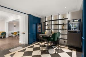 a bar with blue walls and a checkered floor at H&ocirc;tel le Royal Rive Gauche in Paris