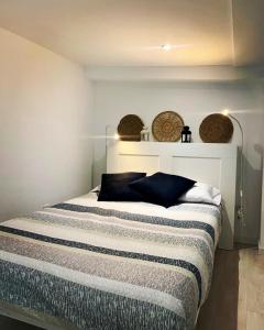 a bedroom with a bed with blue pillows on it at Gure Torrontero in Bermeo