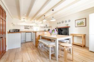 cocina con mesa y algunas sillas y mesa en Stable Cottage 2 bedrooms with gorgeous views, en Dunblane