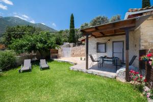 a garden with a patio and a table and chairs at Villa Nika in Palaiokhóri