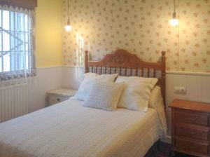 1 dormitorio con 1 cama grande con almohadas blancas en Casa La Bolera, en Carreña