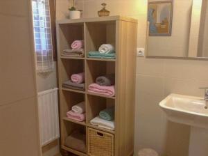un estante de toallas en un baño con lavabo en Casa La Bolera, en Carreña