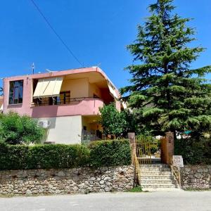 a pink house with a tree in front of it at Villa Edi in Vlorë