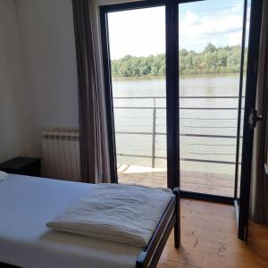 1 dormitorio con cama y vistas al agua en B&B Botel Charlie, en Belgrado