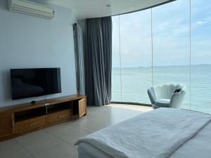 a bedroom with a bed and a television and a chair at Nancy Tran Grand Strip Vung Tau Villa 8 in Vung Tau