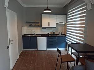 een keuken met blauwe kasten en een tafel en stoelen bij Merve Apart Hotel in Alanya