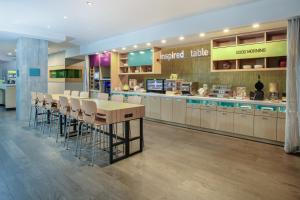 un ristorante con bancone e un bar con sgabelli di Home2 Suites By Hilton Vero Beach I-95 a West Vero Corridor
