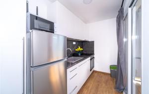 a kitchen with a stainless steel refrigerator and white cabinets at Pet Friendly Home In Cerovacki Galovici in Galović-Selo