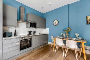 een keuken met blauwe muren en een tafel en stoelen bij ☆☆☆ Brighton Lanes by Creatick ☆☆☆ in Brighton & Hove