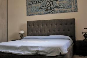 a bedroom with a large bed with a large headboard at Casa Scupoli Relax House Otranto in Otranto