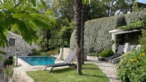 un patio con 2 sillas y una piscina en House in the Mountains near Budva, en Budva