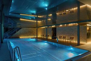 a swimming pool with blue lights in a building at Hotel Tetřeví Boudy in Pec pod Sněžkou