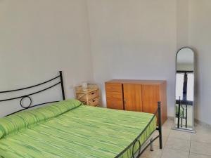 1 dormitorio con cama, tocador y espejo en Residence L'Ancora, en Castelsardo