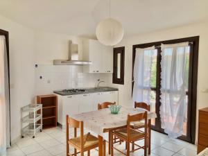 cocina con mesa blanca y sillas y cocina con mesa en Residence L'Ancora, en Castelsardo