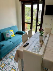ein Wohnzimmer mit einem Tisch und einem blauen Sofa in der Unterkunft Luxury Apartment Vanacore in Castelnuovo Cilento