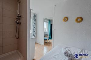 um quarto com um chuveiro e uma cama e uma casa de banho em L'Améthyste City WIFI em Perpignan