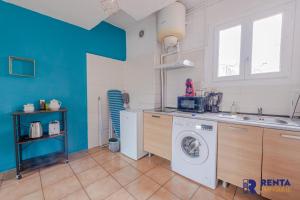 uma cozinha com uma máquina de lavar roupa e um lavatório em L'Améthyste City WIFI em Perpignan