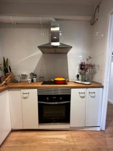 a kitchen with white cabinets and a black oven at Plaza Spain Barcelona Apartments in Barcelona