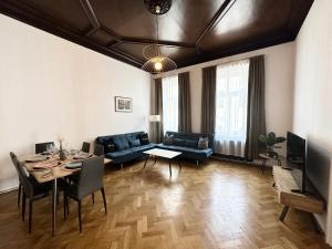 ein Wohnzimmer mit einem Sofa und einem Tisch mit Stühlen in der Unterkunft Hotel Columbia in Wien