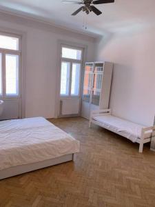 1 dormitorio blanco con 1 cama y ventilador en AIR-CONDITIONED LARGE APARTMENT, en Viena