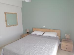 1 dormitorio con cama blanca y espejo en Konstantina, en Néa Thésis