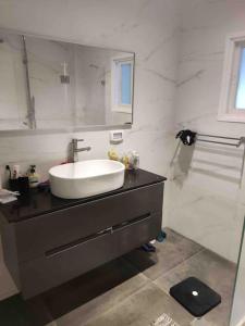 a bathroom with a sink and a mirror and a shower at Maison herzliyah pitouach 5 minutes à pied la plage in Herzliya