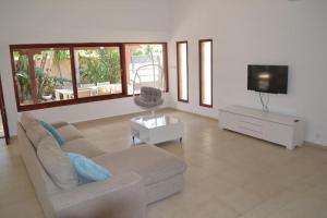 ein Wohnzimmer mit einem Sofa und einem Flachbild-TV in der Unterkunft Maison herzliyah pitouach 5 minutes à pied la plage in Herzlia