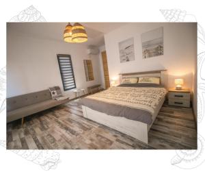 a bedroom with a large bed and a wooden floor at Flip Flop Bungalows in Vadu